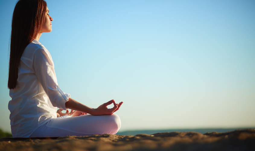 Uma mulher praticando técnicas de mindfulness e relaxamento para controlar o estresse